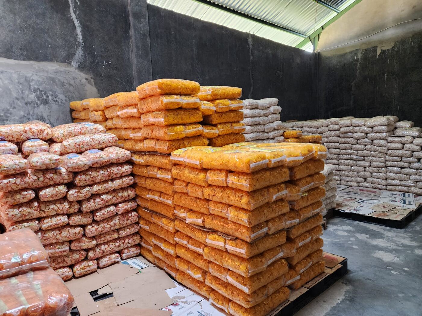 Packaged shrimp and onion crackers stacked in the AshaFry warehouse